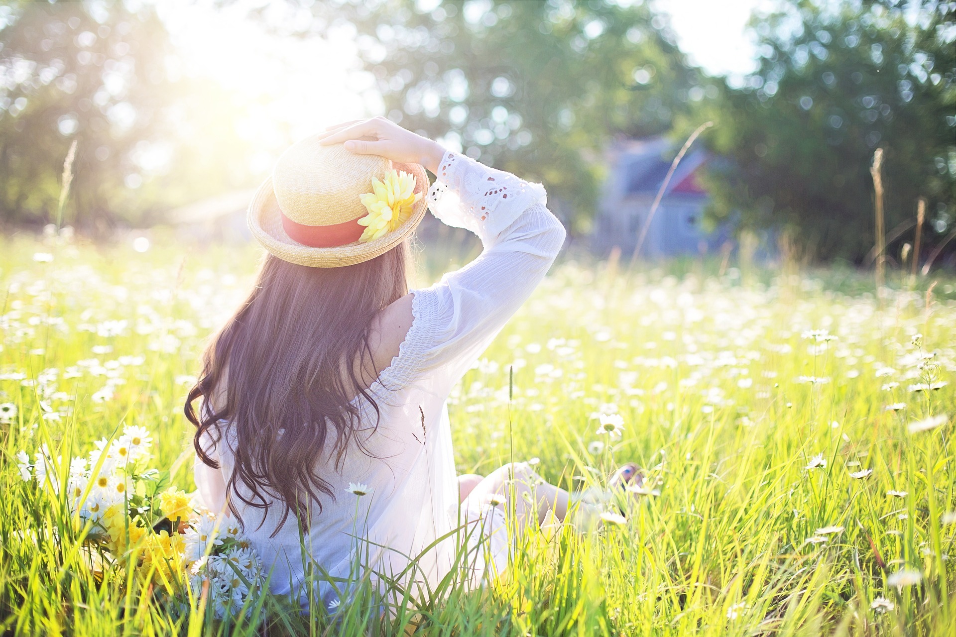 A girl sitting in a field on a sunny day