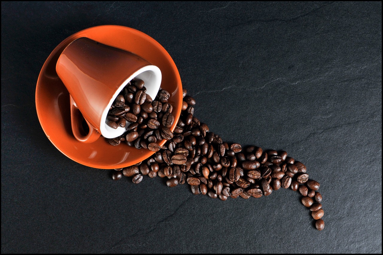 A mug of coffee beans spilled over