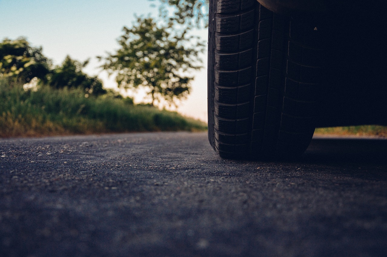 A car's wheel parked on a pavement