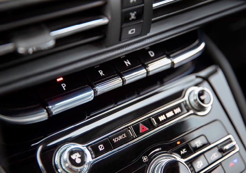 The Park button on the elegant Piano Key Shifter is lit up and engaged as light dances off the chrome accents and horizontal design lines | Asheville Lincoln in Asheville NC