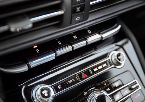 The Park button on the elegant Piano Key Shifter is lit up and engaged as light dances off the chrome accents and horizontal design lines | Asheville Lincoln in Asheville NC
