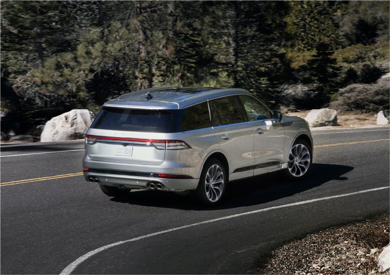 A 2023 Lincoln Aviator® Grand Touring model is shown being driven on a tight turn of a mountain road | Asheville Lincoln in Asheville NC
