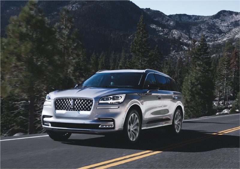 A 2023 Lincoln Aviator® Grand Touring SUV being driven on a winding road to demonstrate the capabilities of all-wheel drive | Asheville Lincoln in Asheville NC