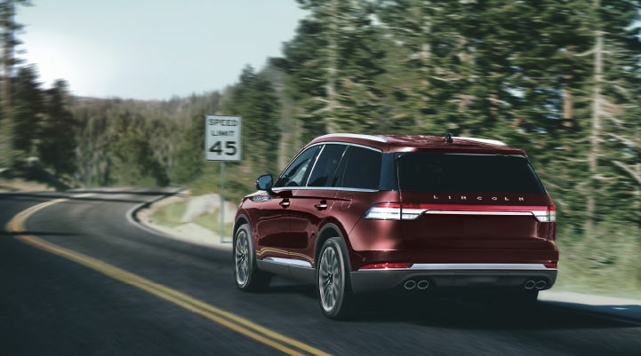 A 2024 Lincoln Aviator® SUV is being driven on a winding mountain road | Asheville Lincoln in Asheville NC