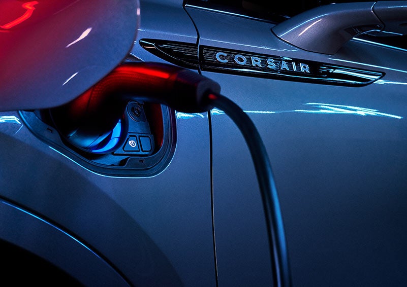 A 2024 Lincoln Corsair® Grand Touring model is shown being charged via the driver’s side charging port.