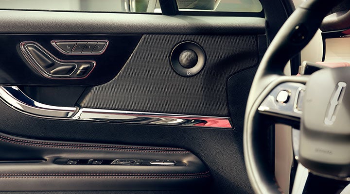 A Revel® audio speaker is shown in the driver's side door of a 2024 Lincoln Corsair® SUV.