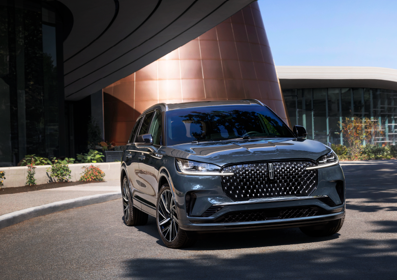 A gray 2025 Lincoln Aviator® SUV is parked outside a modern building with the sun shining. | Asheville Lincoln in Asheville NC