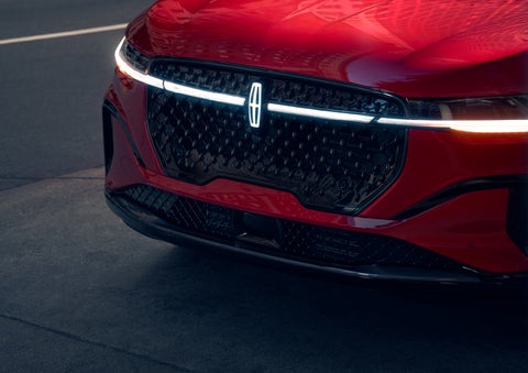The available front LED light bar and center Lincoln Star logo glow at dusk. | Asheville Lincoln in Asheville NC