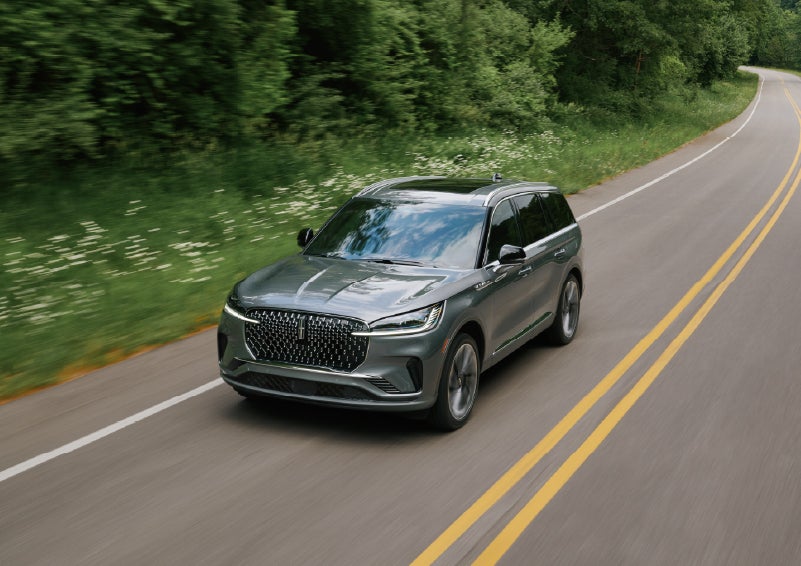 A 2027 Lincoln Aviator® SUV is being driven down a road. | Asheville Lincoln in Asheville NC