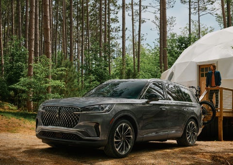 A 2027 Lincoln Aviator® is parked next to a high end glamping site. | Asheville Lincoln in Asheville NC