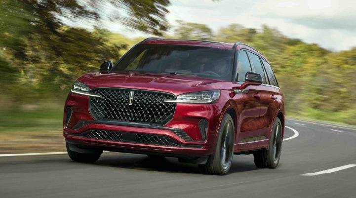 A 2027 Lincoln Aviator® SUV is being driven on a country road | Asheville Lincoln in Asheville NC