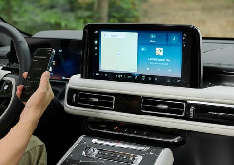 A person pairs thier phone with the center touchscreen of a 2027 Lincoln Aviator® Black Label™ SUV | Asheville Lincoln in Asheville NC
